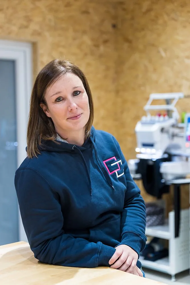 Géraldine Collinge devant sa brodeuse, dans l'atelier de Modave